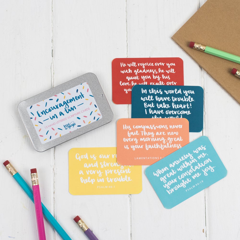 15 brightly coloured hand lettered scripture cards with encouraging scriptures presented in a slide-top tin
