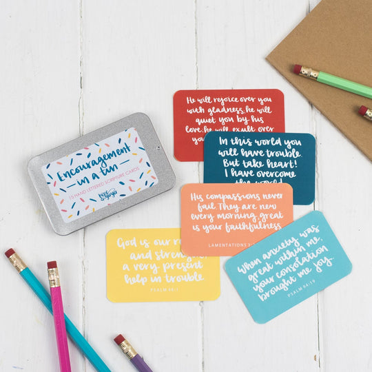 15 brightly coloured hand lettered scripture cards with encouraging scriptures presented in a slide-top tin
