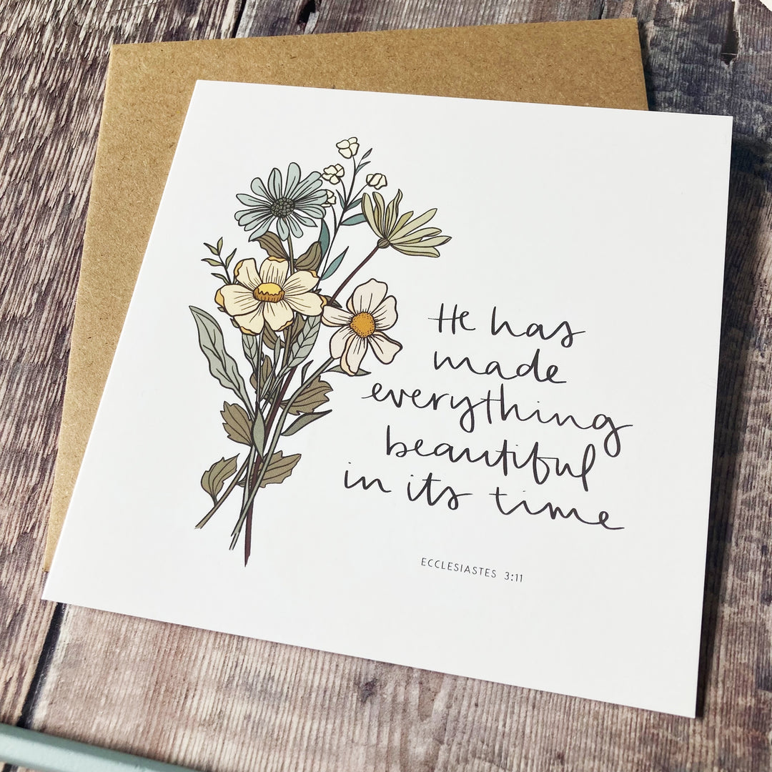 Greeting card with floral design and text on a wooden surface