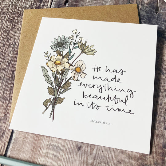 Greeting card with floral design and text on a wooden surface