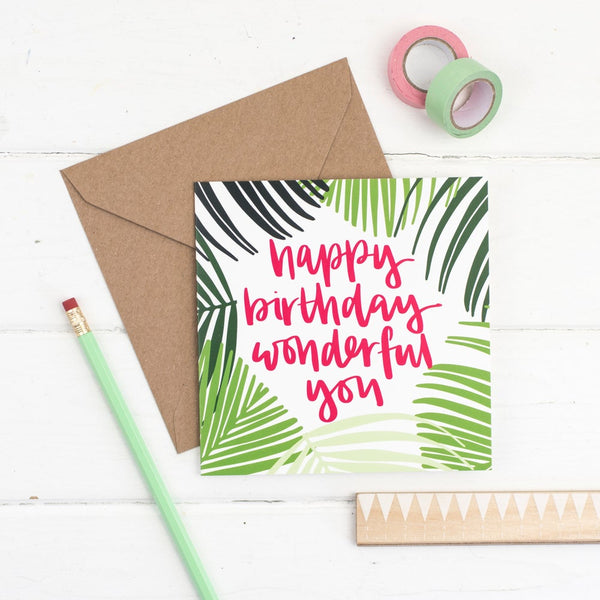 Happy birthday wonderful you raspberry lettering and a hand drawn palm frond illustration square card with kraft envelope 