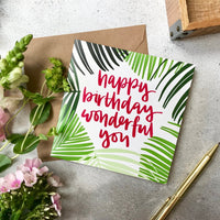 Happy birthday wonderful you raspberry lettering and a hand drawn palm frond illustration square card with kraft envelope