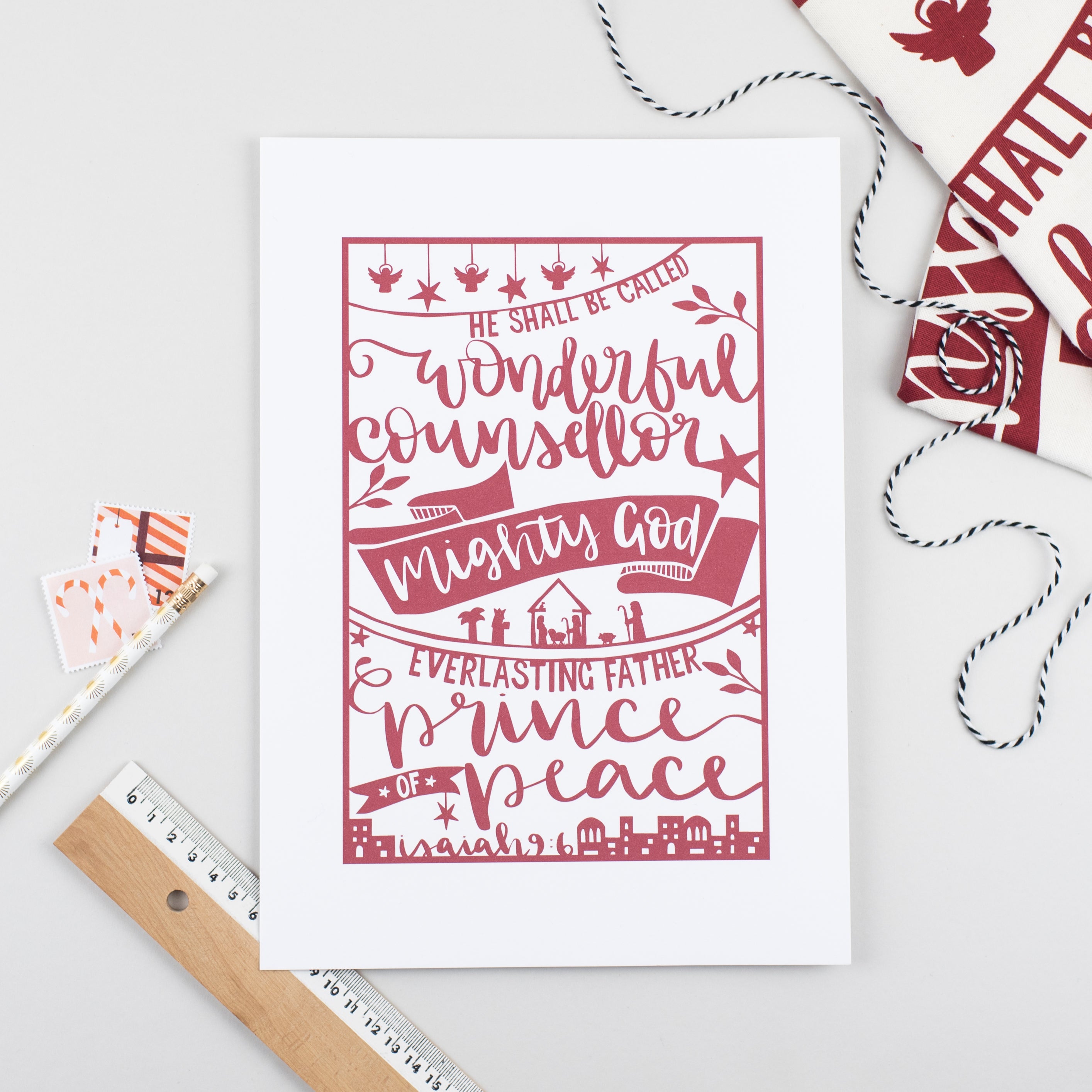 Festive print printed with a hand-drawn paper cut style design in red on white featuring the beautiful words of Isaiah 9:6 